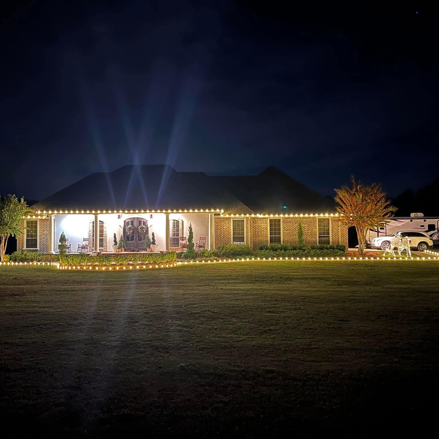 Warm white roofline and landscape Christmas lighting on a large home
